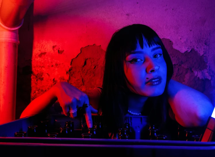 woman in an underground room holding out her hand to sound on a turntable