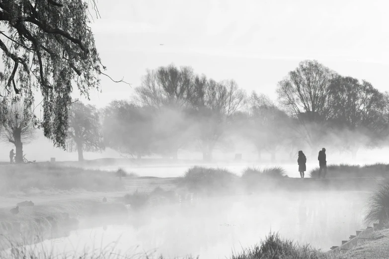 black and white pograph of people fishing in the lake