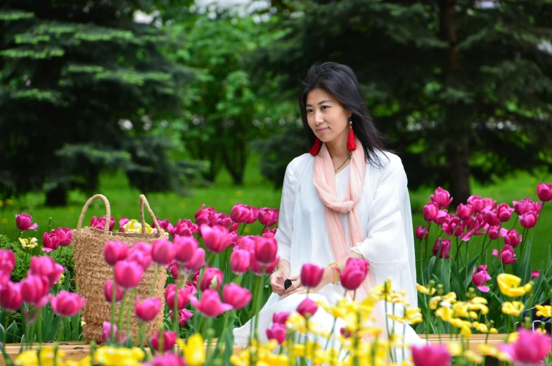 a woman wearing a white outfit standing in a field of flowers