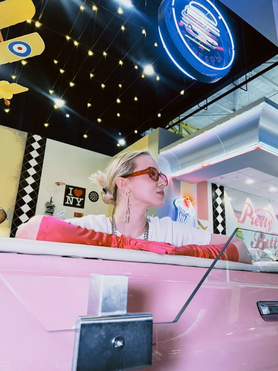 a woman wearing pink glasses sitting in the back of a car