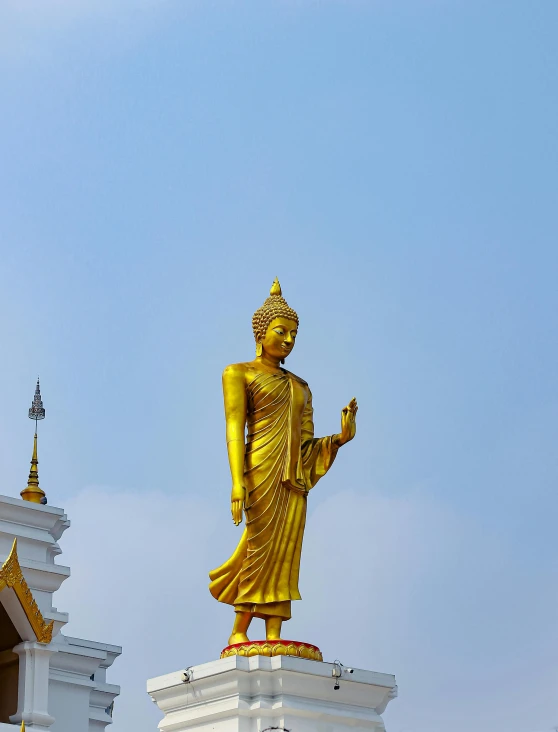 there is a gold buddha statue on the roof of this building