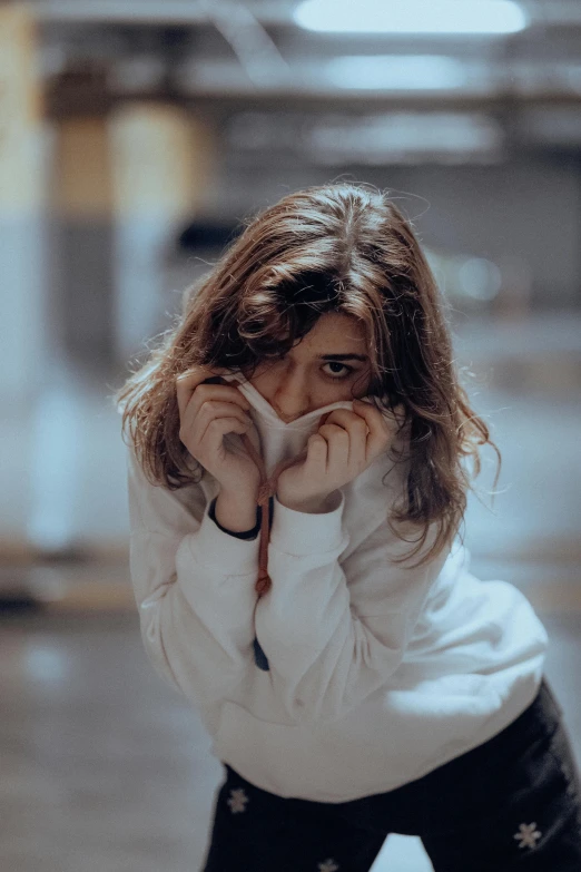 a woman poses with her hand on her face