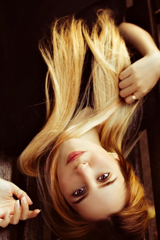 a young woman with long blonde hair laying on the ground