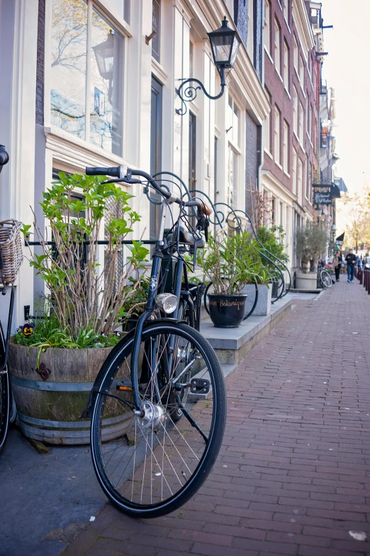 two bicycles are parked on the side of a brick building