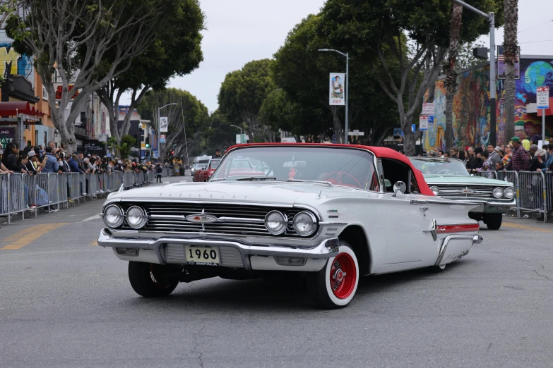 a car with red rims drives down the road