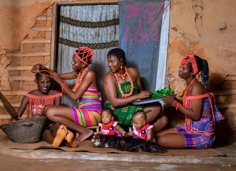 four women are sitting on the floor holding babies