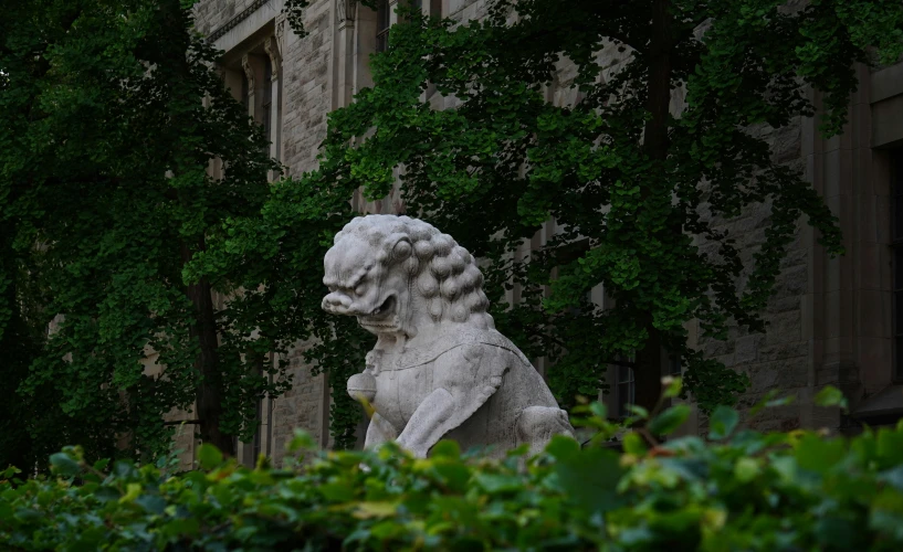 an ornate statue in front of a building with trees