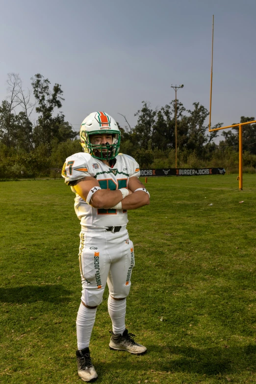 a football player wearing a white uniform and green helmet