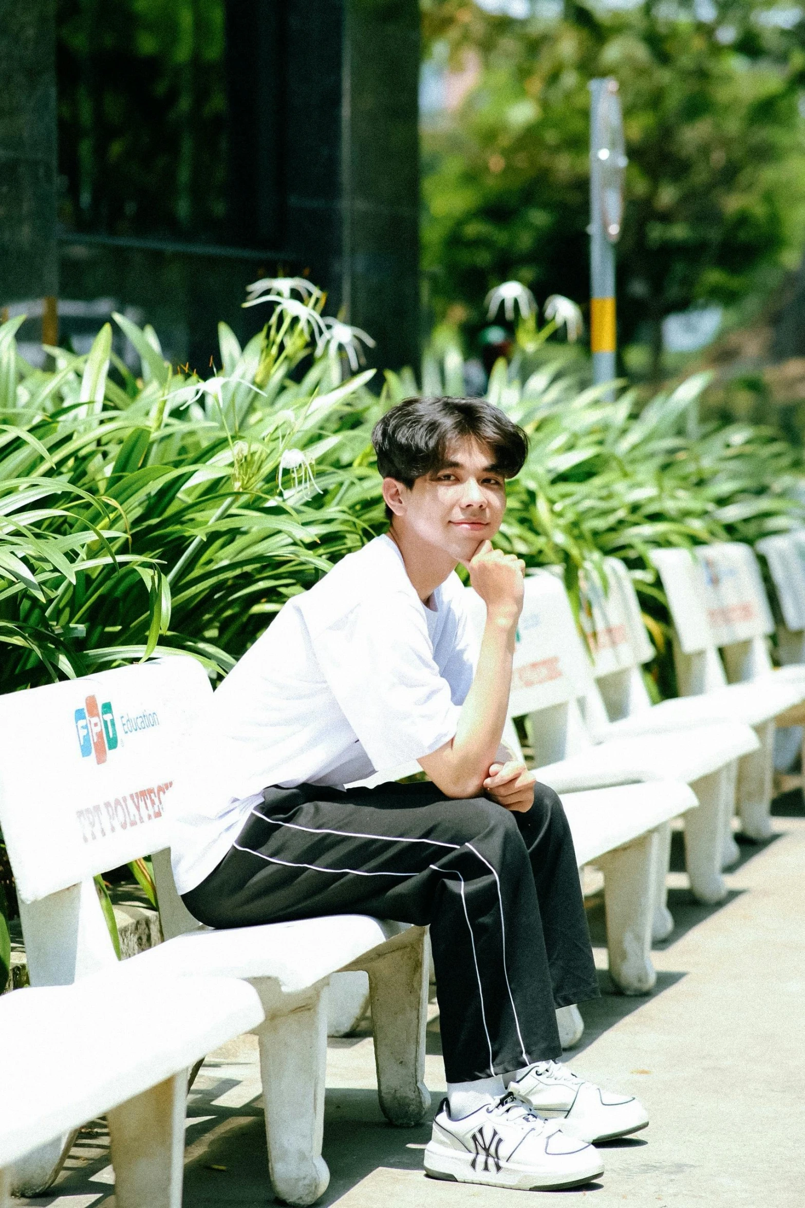 a man sitting on top of a long white bench