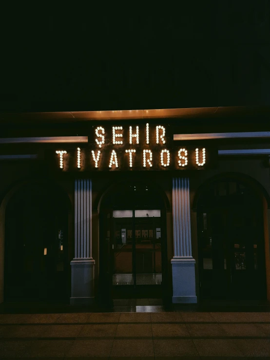 a lit up building that reads sehr tivatriou on the side of it