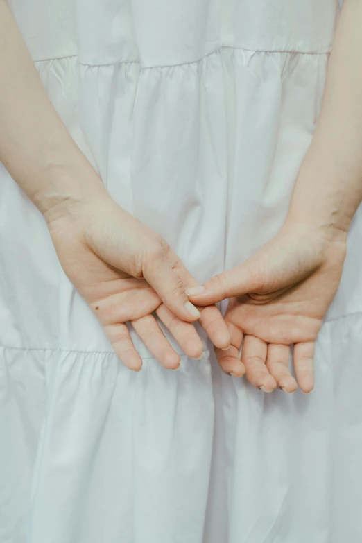 two hands holding onto another hand on top of a dress