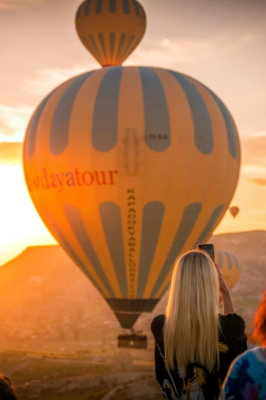 the back of a woman's head while in front of an enormous  air balloon