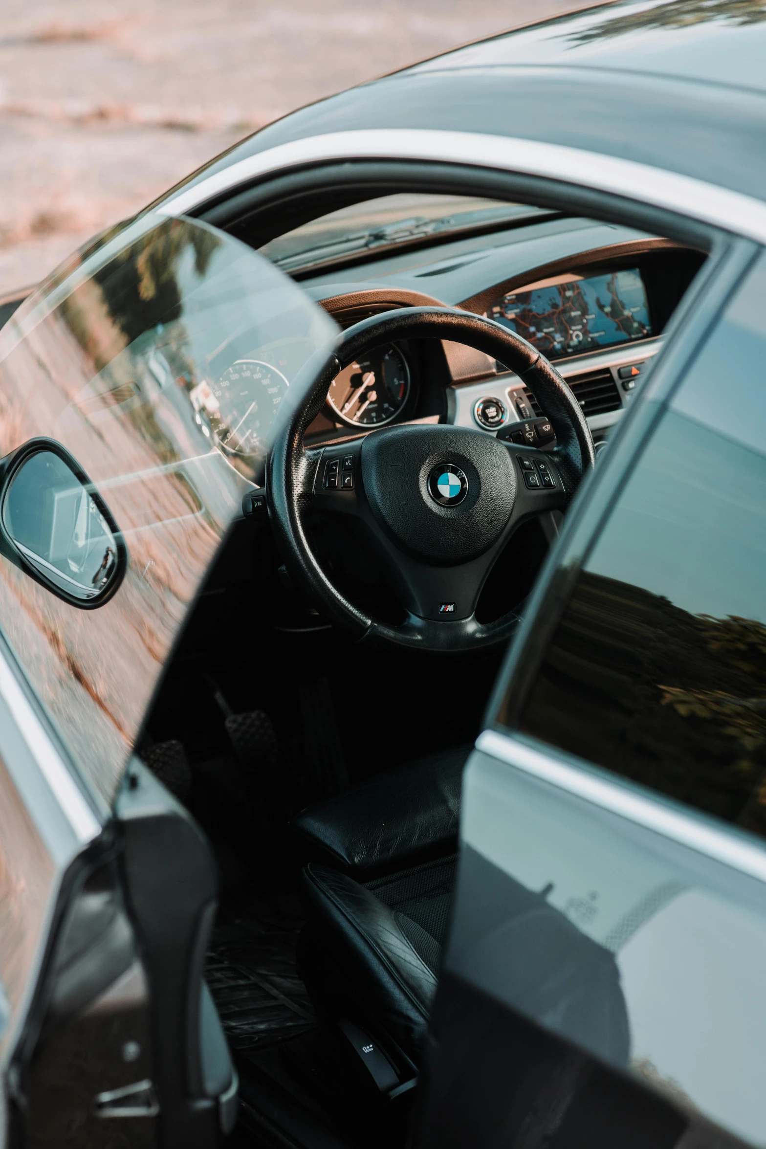 the inside view of a bmw parked near a field