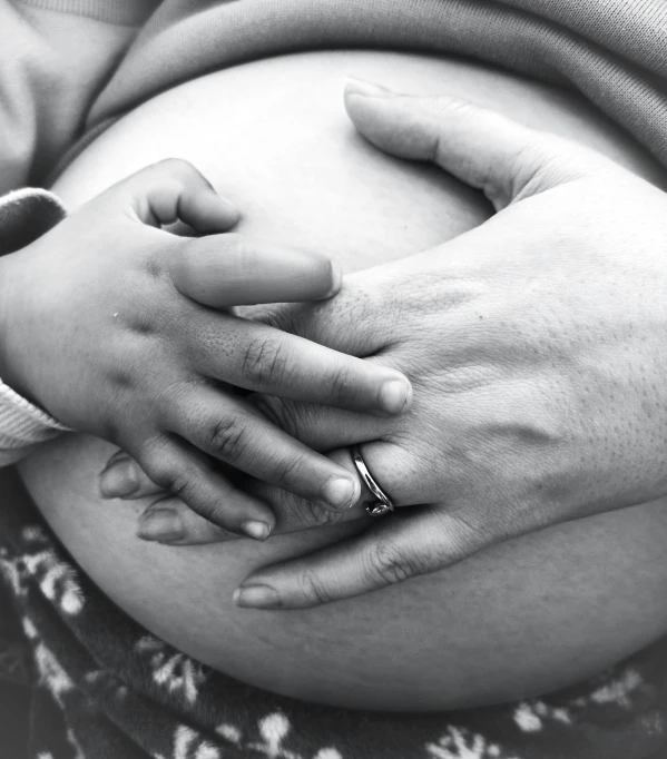 a hand holding the belly of a pregnant woman