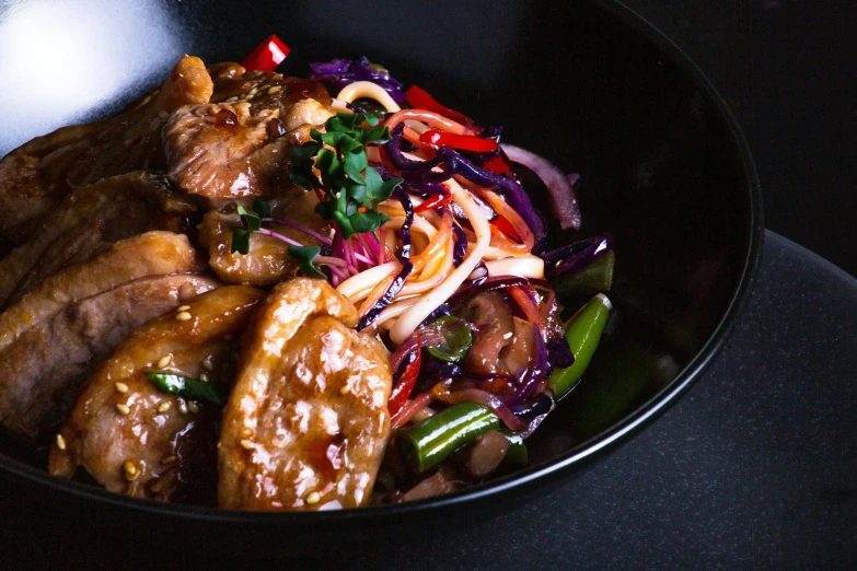 asian cuisine with noodles, rice and meat in a bowl