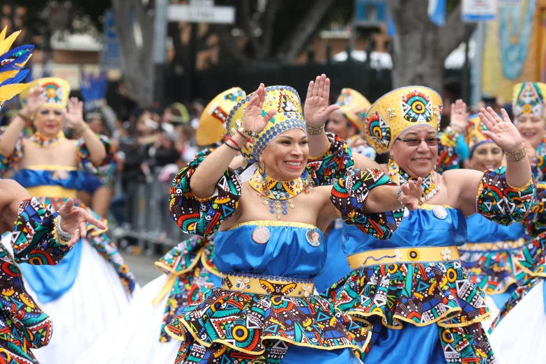 women in elaborately painted costumes performing in a parade