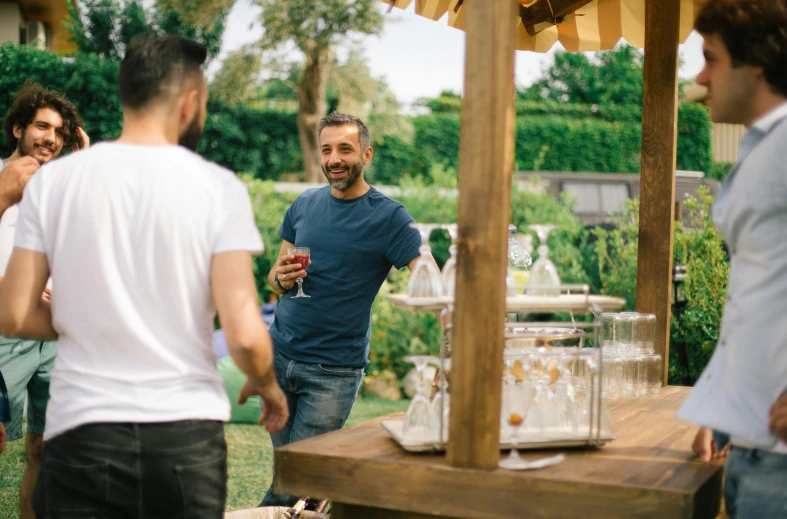 two men and a woman in a back yard talking