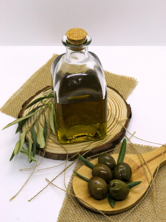 a bottle with olives on a wooden  board