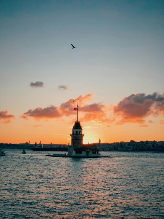 an ocean liner with a clock tower on it at sunset