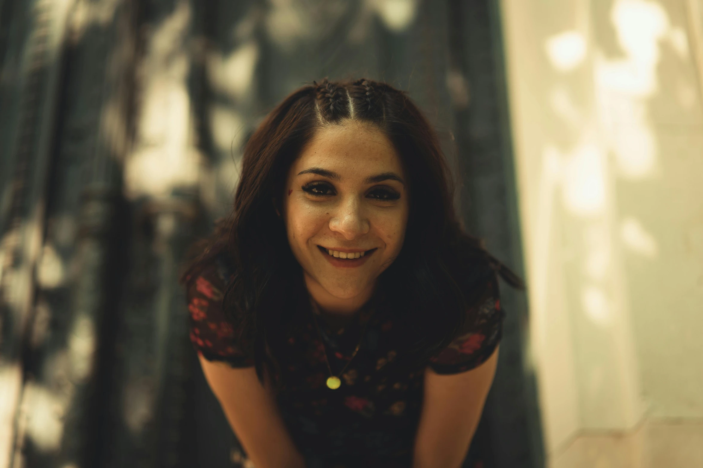 a smiling woman wearing a floral dress poses for a po