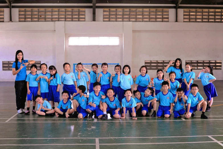 group of people posing on court with sports equipment