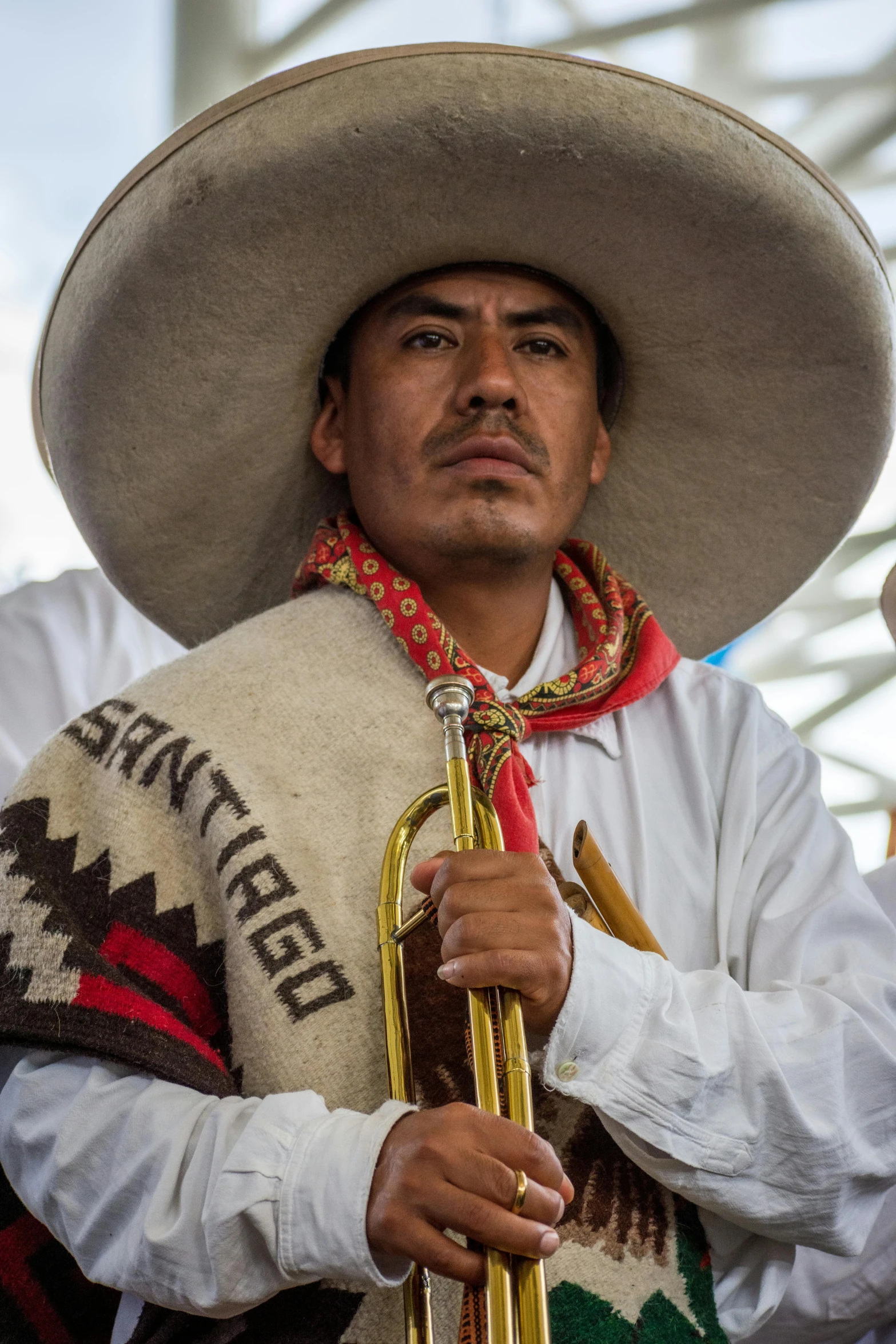 a mexican man wearing an oversized hat and playing the trumpet