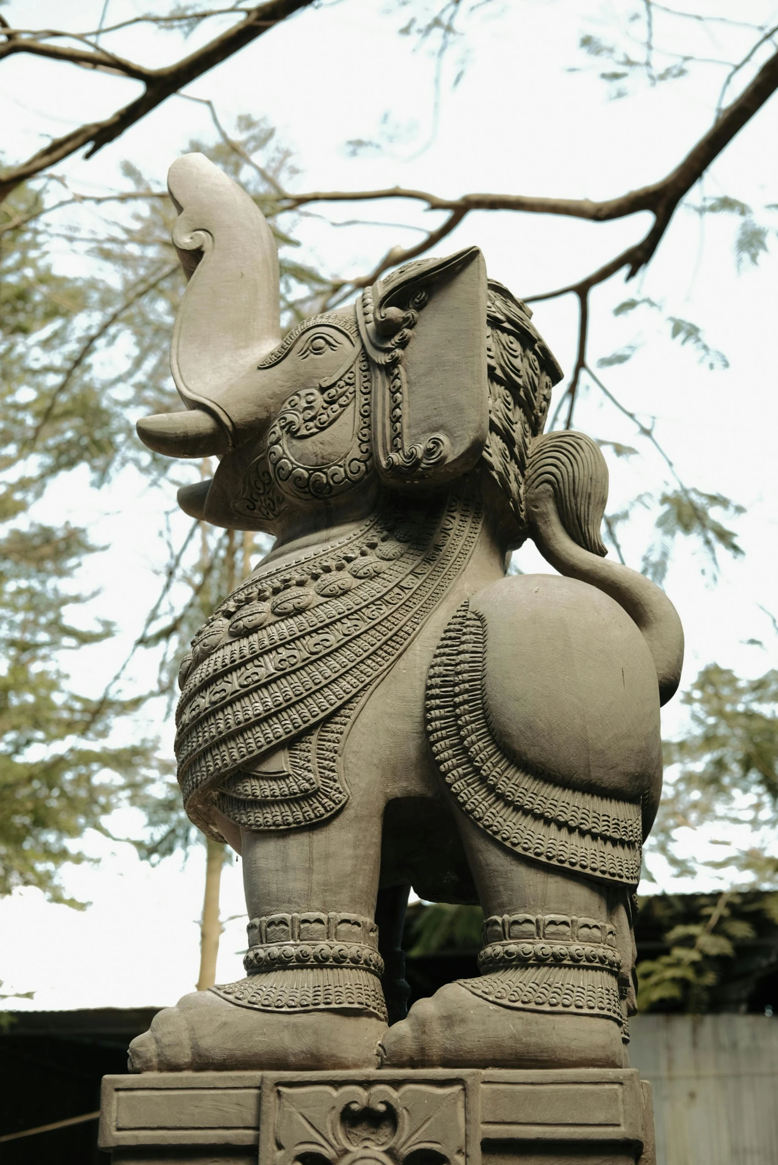 a statue in front of a large tree