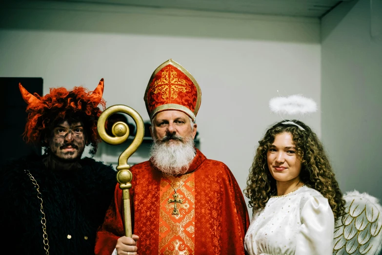 a group of people dressed as gods, including one dressed like a priest