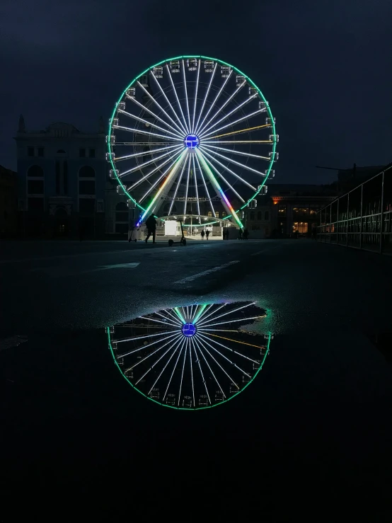 the wheel is reflected in a dle on a dark street