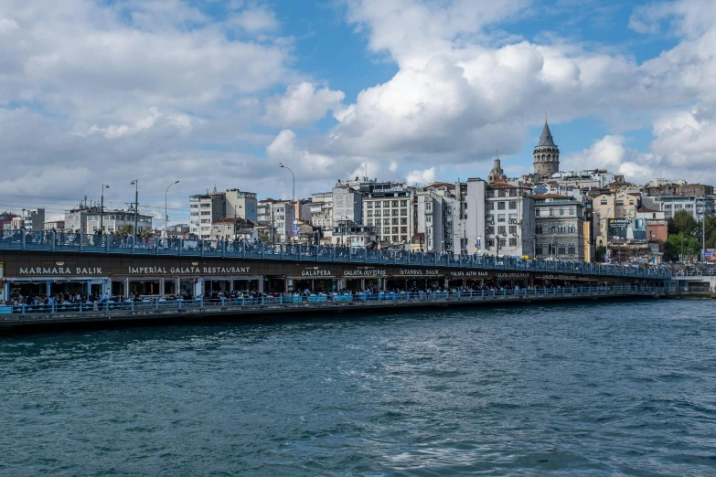 a large blue bridge spanning a large city with tall buildings