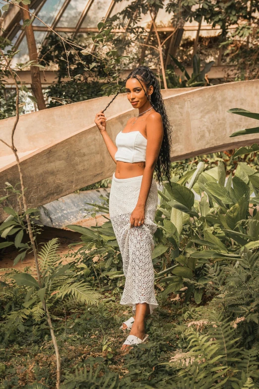 woman in white top holding a bamboo stick