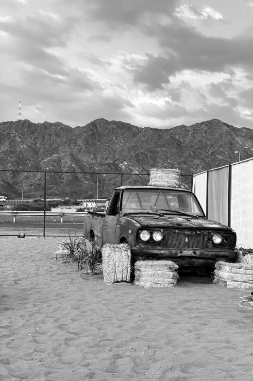 an automobile sits in the dirt next to a trailer