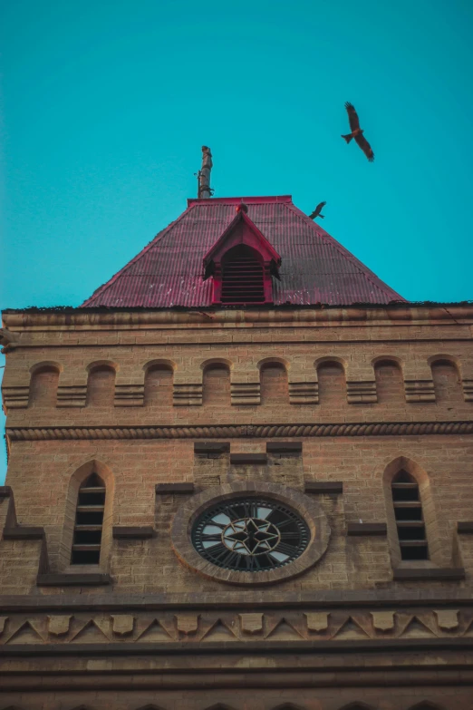 a bird flying in the sky above a stone building