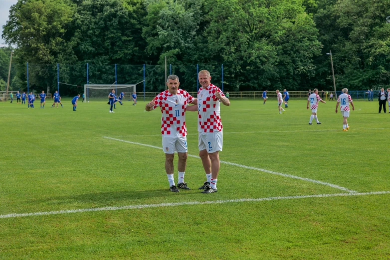 two young men are standing on a soccer field