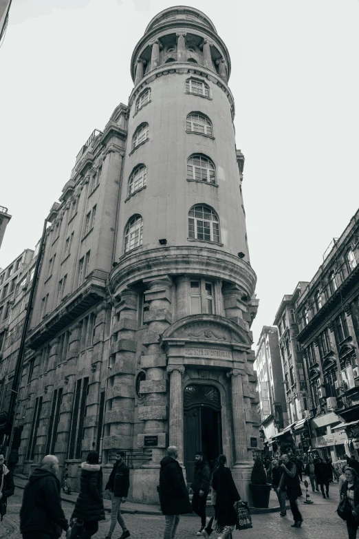 people walking outside of a building with tall buildings