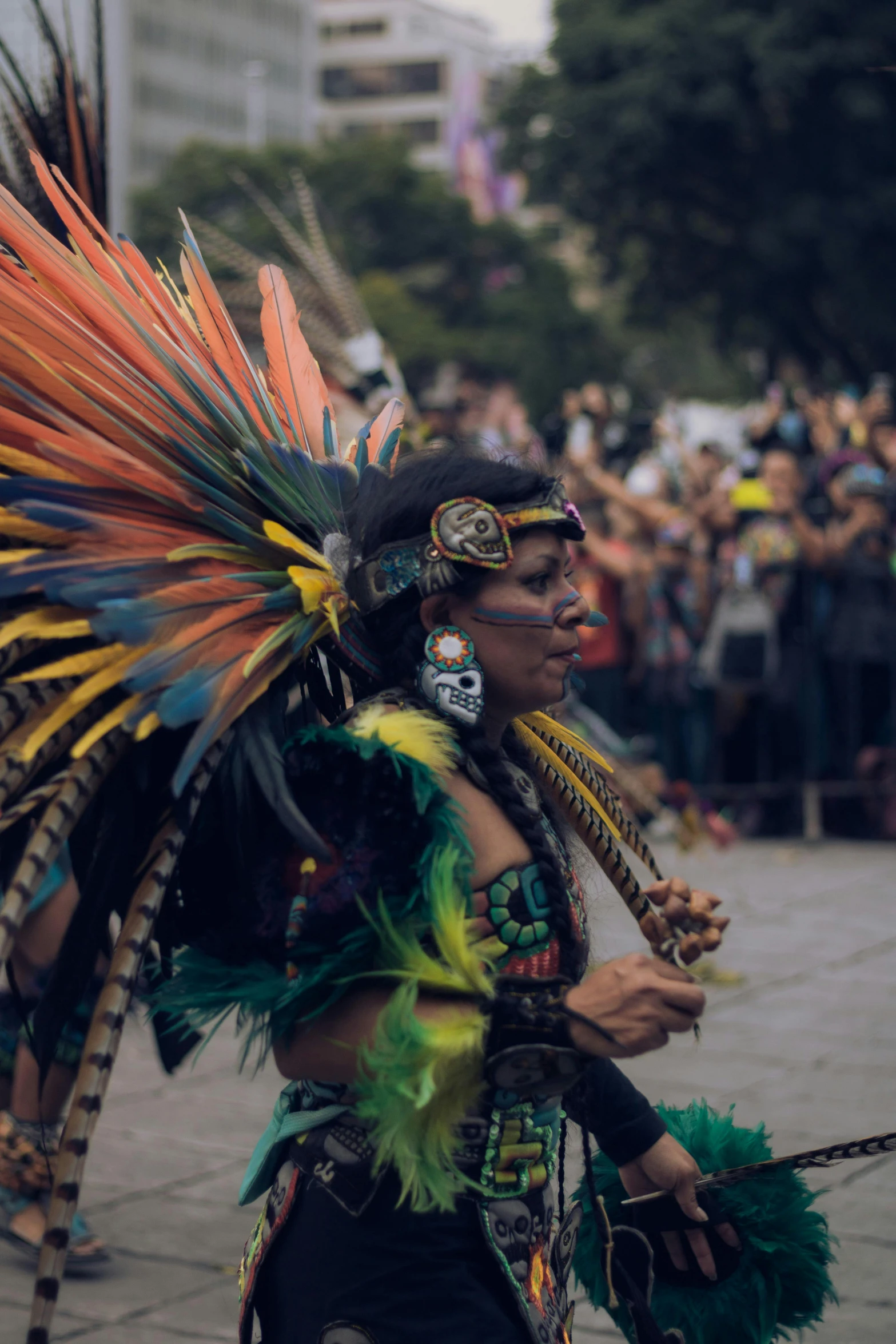 a woman wearing an elaborate feathered headdress while standing in the street