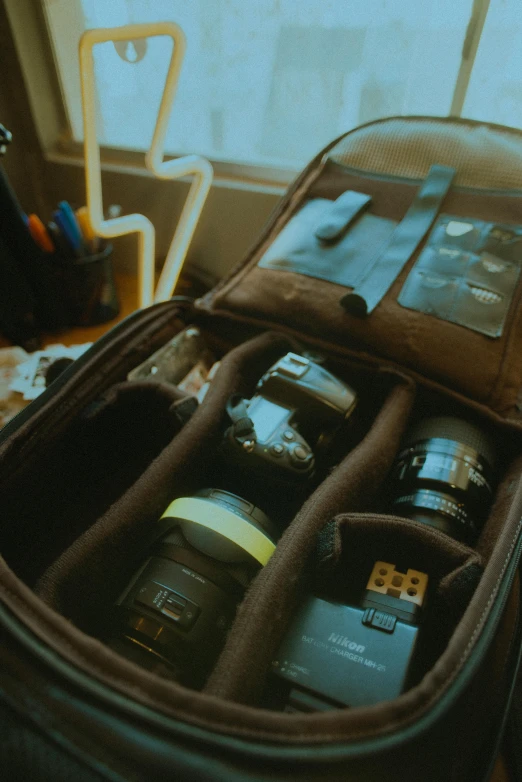 an open brown suitcase with many objects inside