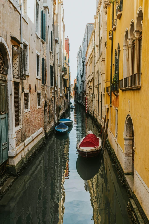 a waterway with a rowboat in it between buildings