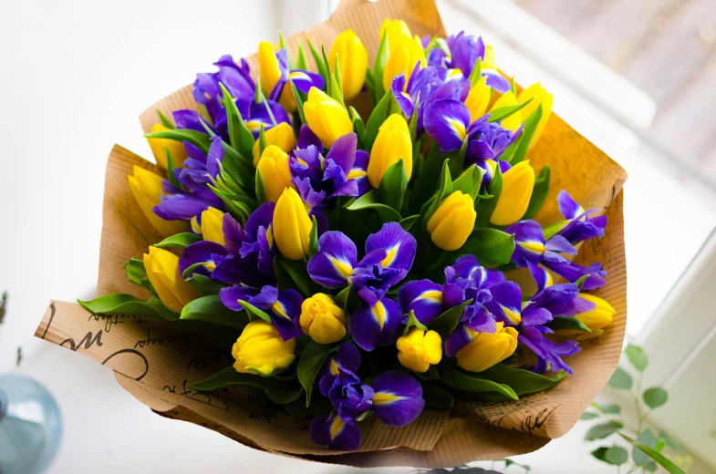 a bunch of purple flowers is laying on a window sill