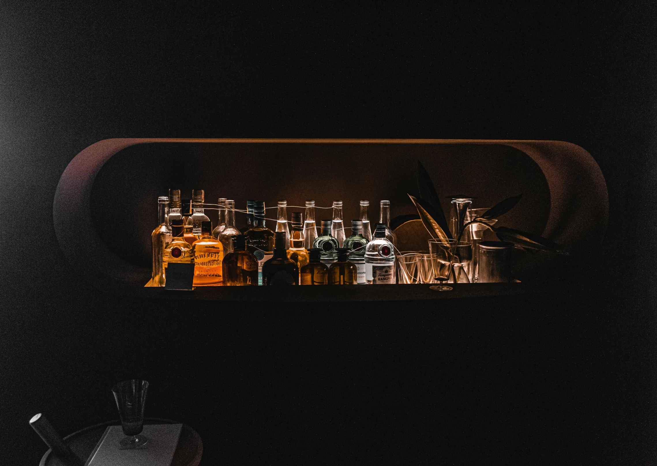 an overhead shelf with several bottles and glasses