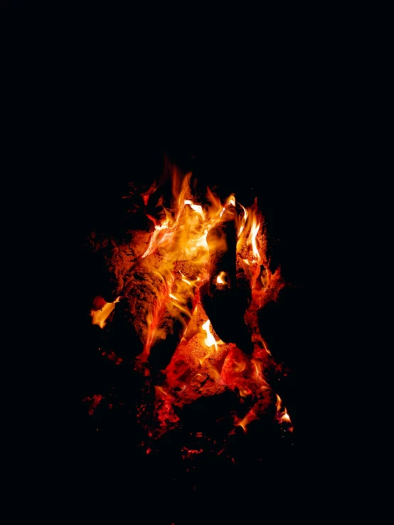 a red and yellow fire burning in the dark