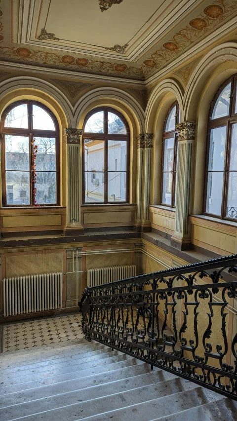 a room that has a railing and windows with bars on them