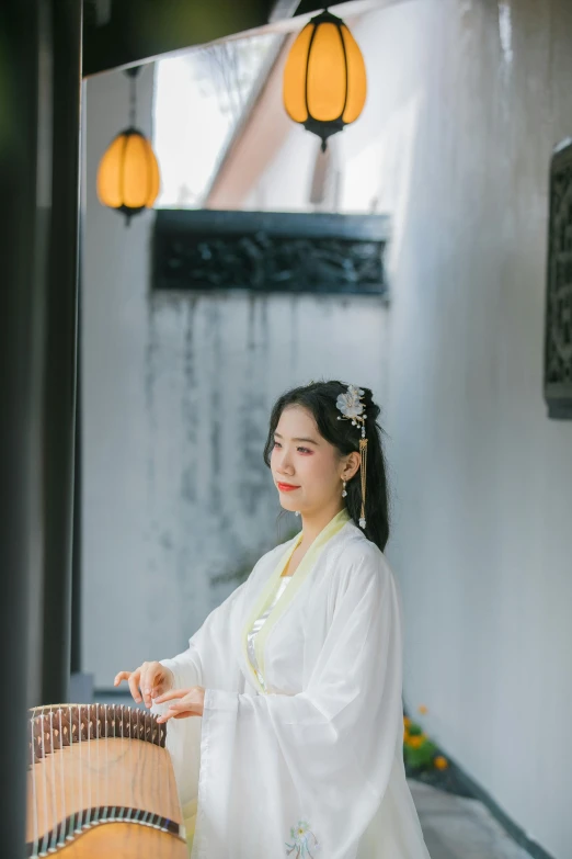 an oriental woman holding a handmade musical instrument