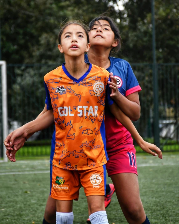 a couple of women kicking around a soccer ball