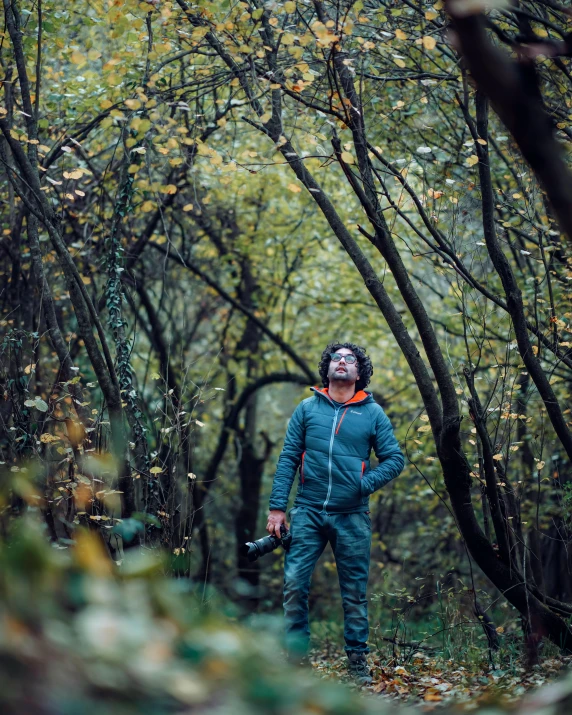 the man is looking up in a tunnel of trees