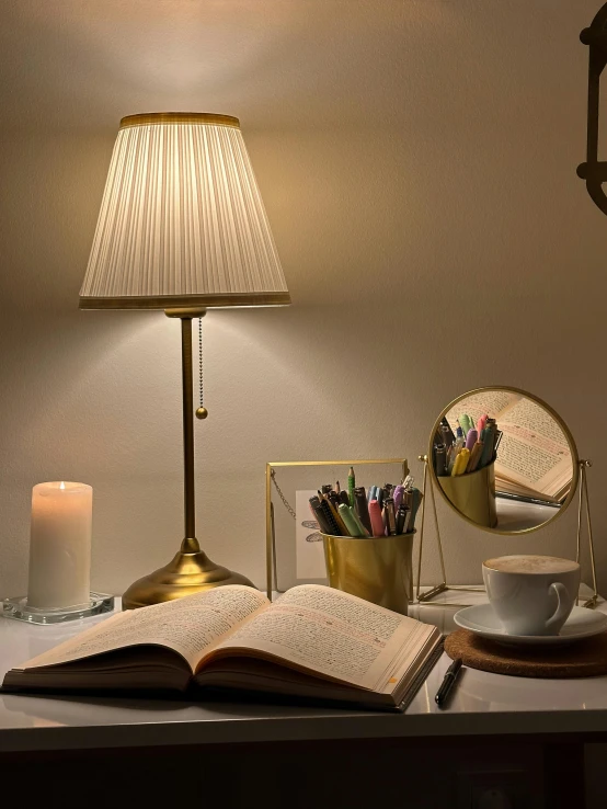 a lit lamp is next to an open book on a table