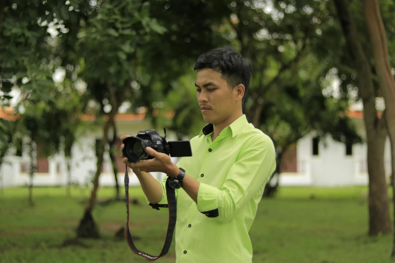 a man with a camera stands on the grass