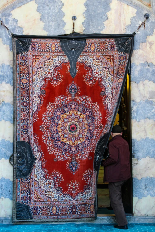 a person looking at an old rug outside