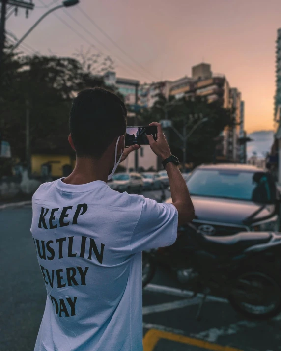 a man standing next to a parked car while taking a picture