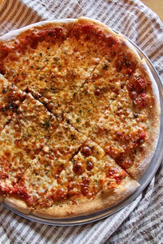 a pizza on top of a plate and a towel